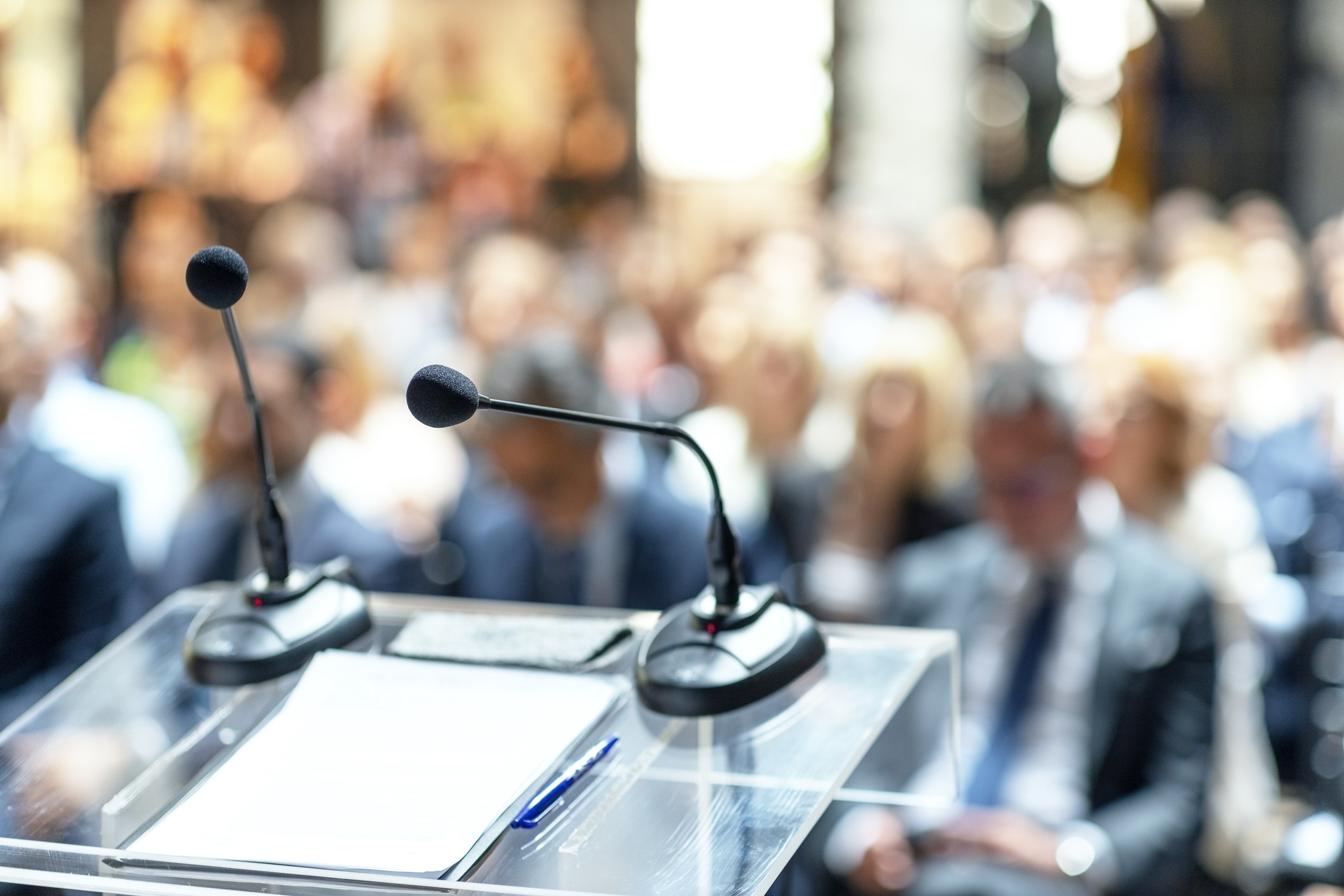 Speaker podium with faded audience in background